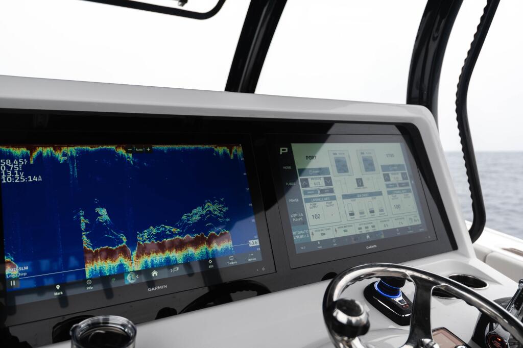 Dual Garmin displays at the helm showing sonar and livewell system controls on a fishing boat