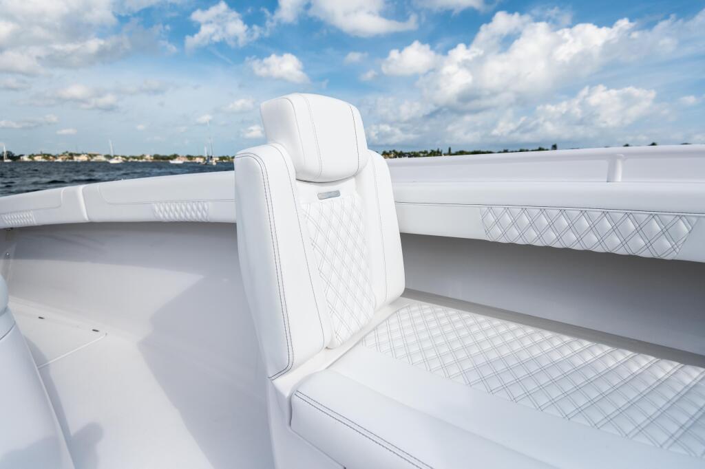 White quilted bow seating with water and distant shoreline under blue sky